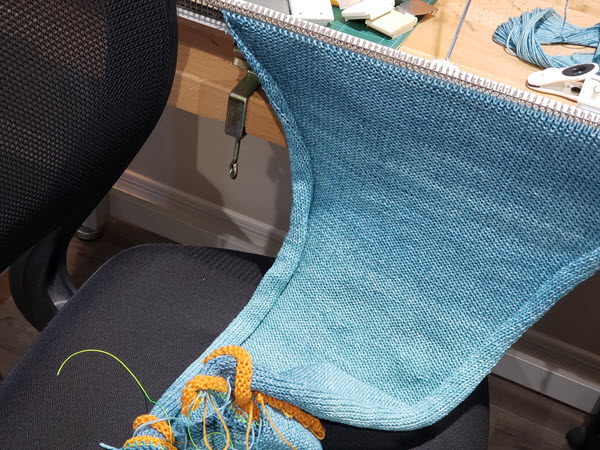 Knitting resting on chair to avoid tension during machine knitting breaks