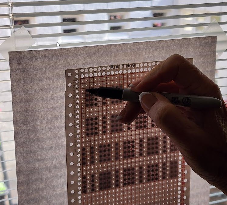 Tracing a stitch diagram onto a punchcard using a window for light